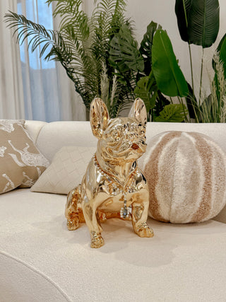 Golden French Bulldog Statue chilling on a couch.