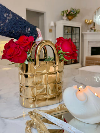 A woman carefully holding a My Golden Purse Ceramic Vase.