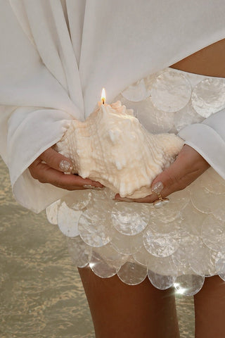 Opaline Conch Seashell Candle - XL beside crystal decor in a luxury suite