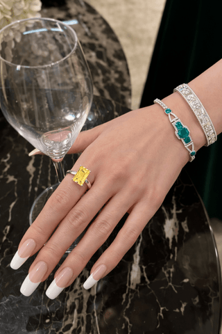 Yellow Sapphire Emerald Cut Ring worn by a hand model.