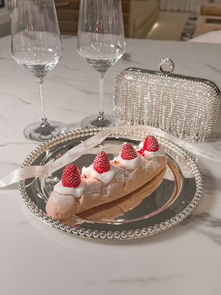 Strawberry & Cream Bread Candle atop a beautiful, elegant plate with tablecloth.