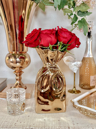 Giovanna Golden Bag Vase with blooming red roses.