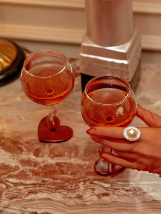 A model gently picking up a “My Valentine” Wine Glass Cup from a marble countertop.