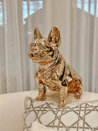 Golden French Bulldog Statue sitting on a couch.