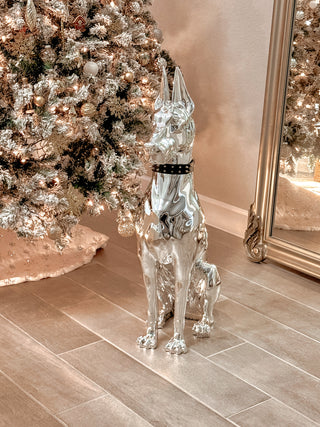 Luxurious Electroplated Doberman Dog Statue in front of lit a Christmas tree and grand mirror.