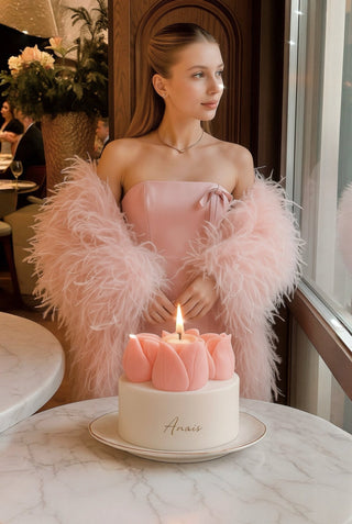 A woman enjoys the lit flame of her new Amélie Tulips Bouquet Candle.