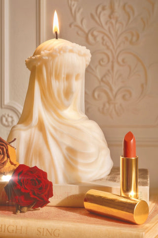 A lit "Amour, Anaïs" candle, part of the Anaïs Greek Sculpture Present Set.