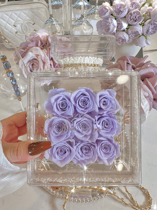 Everlasting Roses in Parfum Box in Plum surrounded by violet and blue-hued florals.