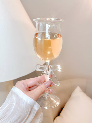 A woman giving a toast with a Charlotte Bow Wine Glass Cup.