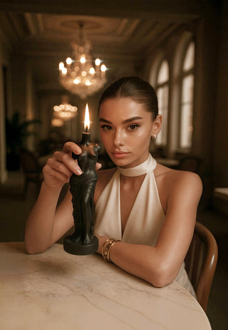 A woman holds the The Venus Candle in Ultra Black in a 5-star hotel setting.