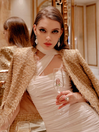 A model holding a La Vie En Rose Champagne Glass in front of a gilded mirror.