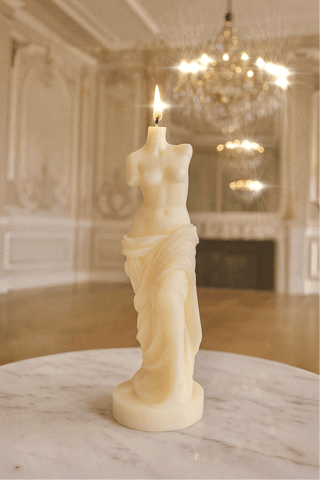 The Venus Candle in Sculpture White pictured amongst crystal chandeliers.