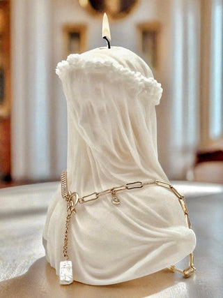 A lit 'Amour, Anaïs' candle with a necklace draped around her shoulders.