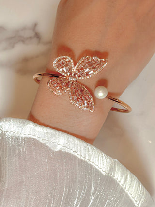 Dreamy Butterfly Bangle Bracelet worn by model atop a marble table.