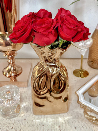 Giovanna Golden Bag Vase decorated with a lush rose bouquet.