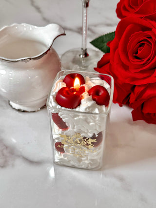 Cherry & Cream Delight Candle atop a marble table.