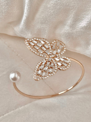 Dreamy Butterfly Bangle Bracelet set on top of a white leather cushion.