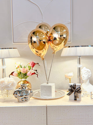 Golden Balloons Sculpture Decor next to crystal lamps and flower vases.