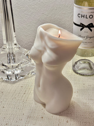Anaïs Feminine Bust Candle and a bottle of wine atop a luxurious credenza.