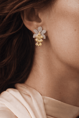 A woman wearing the Rosemary Floral Yellow Sapphire Earrings.
