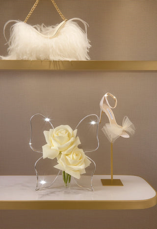 Château Butterfly Acrylic Vase decorated with white florals on a luxury gold shelf.