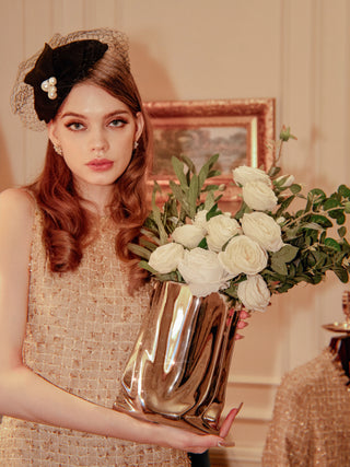 A woman carefully holding a Luxe Bag Vase - Sliver Electroplated.