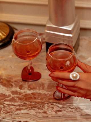 A woman gently picking up a “My Valentine” Wine Glass Cup from a marble table.