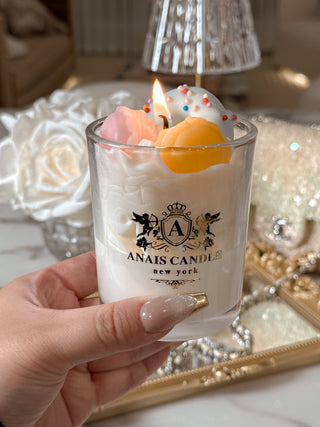 A woman holding a Macaron Parfait Candle with an Anaïs Candle logo.