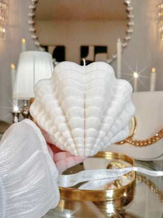 A woman holding a Modern Scallop Shell Candle - XXL.