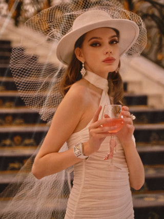 A woman in a white evening gown toasting a Cindarella’s Glass Slippers Wine Glass.