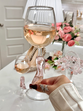 A woman toasting a Cindarella’s Glass Slippers Wine Glass.