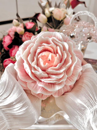 A woman with silk sleeves holding a Blooming Peony Candle - XXL.