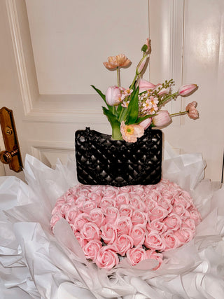 Anastasia Handbag Resin Vase in Ultra Black on top of a massive pink rose bouquet.