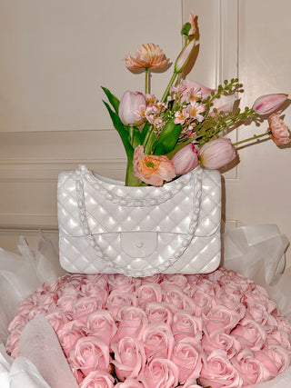 Anastasia Handbag Vase in White decorated with a pink floral bouquet.