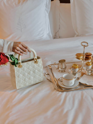 Scarlett Handbag Resin Vase on a hotel bed.