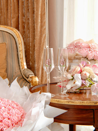 La Vie En Rose Champagne Glass Set of 2 surrounded by blooming pink floral bouquets.