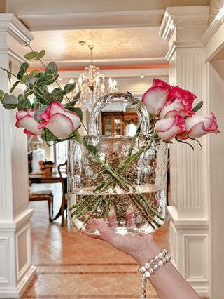 Anais Candle's Olivia Glass Handbag Vase decorated with blooming florals in a luxurious hallway.