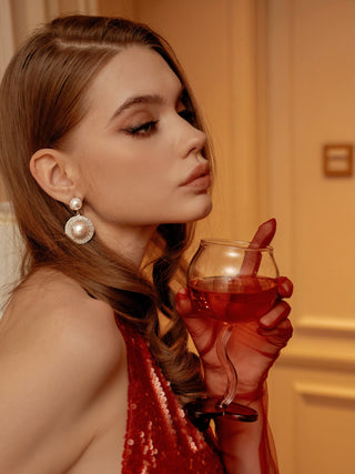 A model wearing a red sequin dress, gently holding a “My Valentine” Wine Glass Cup.