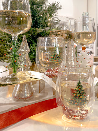 Christmas Confetti Glass Cup Set of 2 surrounded by wine and wine glasses.