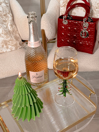 Christmas Tree Glass Cup - Handmade next to a lit Christmas tree candle.