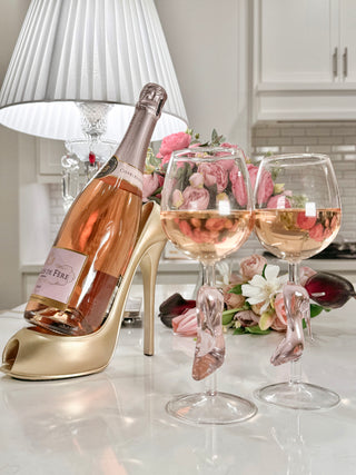 Cindarella’s Glass Slippers Wine Glasses, Set of 2 next to a bottle of pink champagne.