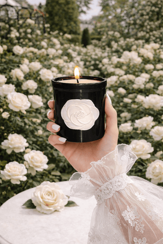 A model holds the Camellia Élégance Candle in her huge floral garden