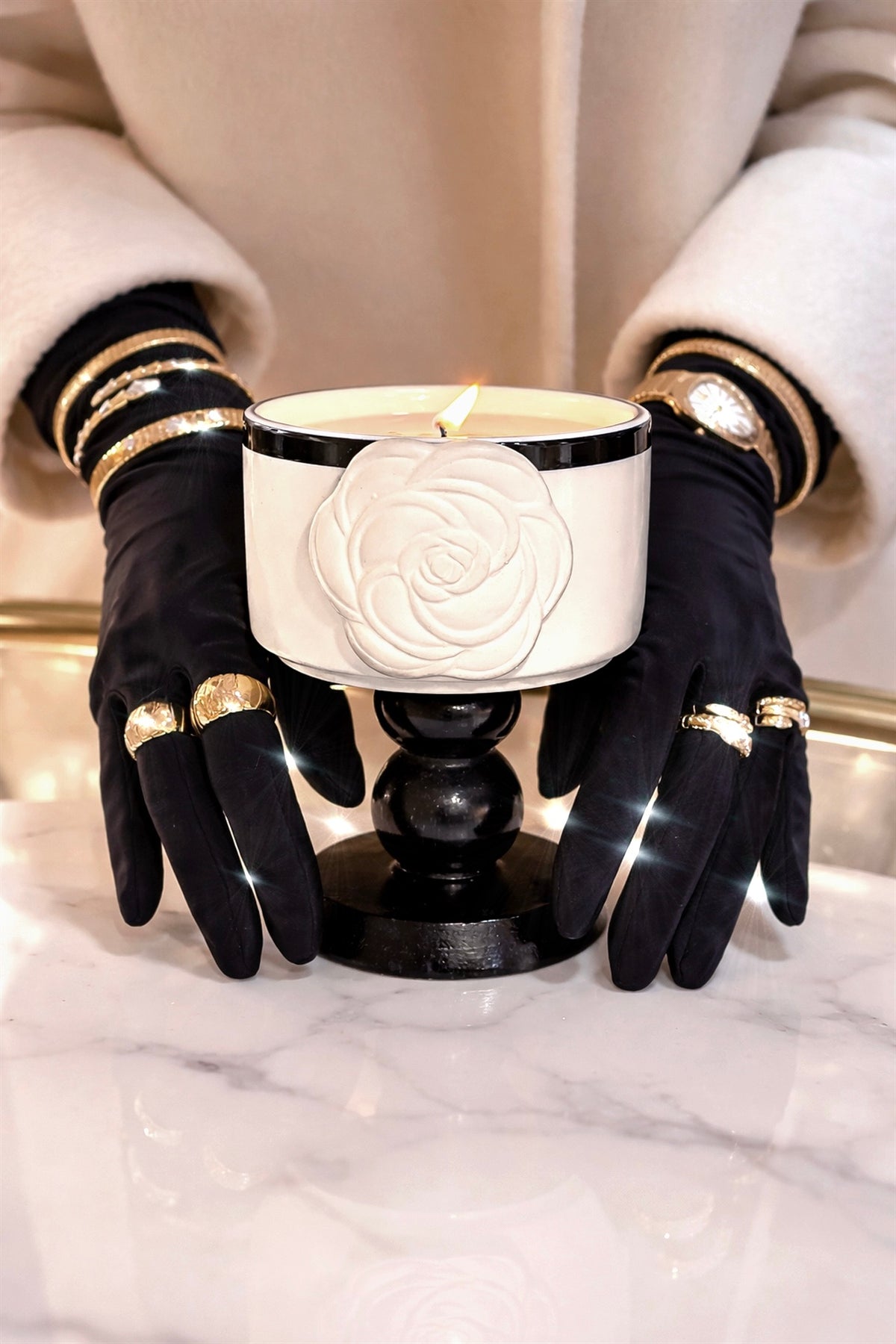 Sculptural white camellia candle held on a marble table