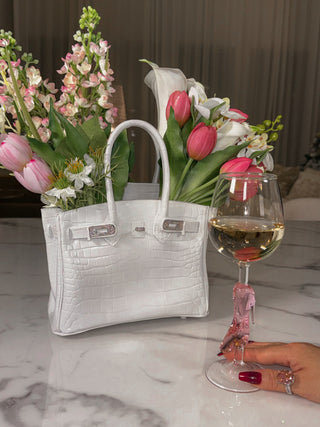 Sandra Handbag Resin Vase styled with lush florals next to a Cindarella's Glass Slipper Wine Glass.