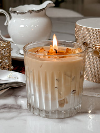 A lit Iced Caffè Candle on a beautiful marble table.