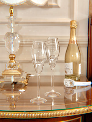 ‘100-Carat’ Diamond Champagne Flute Set of 2 on a luxurious nightstand with gold champagne.