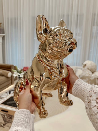 Golden French Bulldog Statue held by a woman.