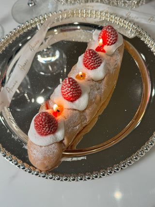 Strawberry & Cream Bread Candle atop a beautiful, elegant plate.