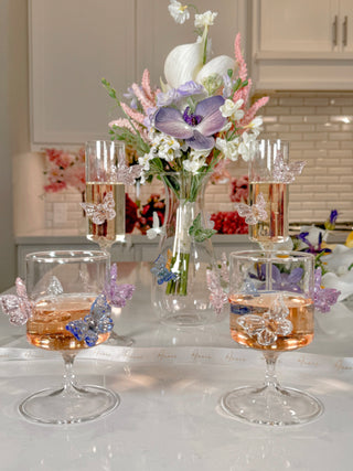 An Anais Butterfly Whispers Glass Vase surrounded by other Butterfly glassware.