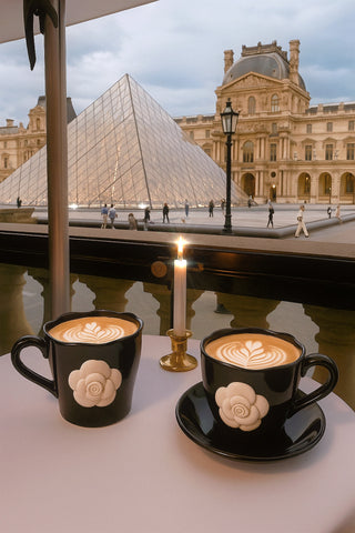 The Camellia Romance Ceramic Tea/Coffee Cup Set of 2 outdoors at a Parisian Coffee Shop.